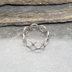 A silver ring made from a band of 8 sterling silver circles. A single band of delicate silver circles to adorn your finger. An unusual and sophisticated handmade piece. Circles are a symbol of eternity and karma. A sweet gift for a friend or loved one. Wear with my other circle ring for even more of a statement! Elegant Sterling Silver Full Circle Ring, Anniversary Sterling Silver Stackable Circle Rings, Elegant Full Circle Sterling Silver Rings, Hypoallergenic Silver Stackable Round Band Rings, Modern Silver Hypoallergenic Stackable Rings, Modern Hypoallergenic Silver Stackable Rings, Handmade Silver Stackable Rings With Round Band, Minimalist Round Stackable Metal Rings, Elegant Silver Circle Midi Rings