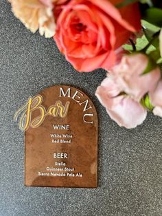 a plaque on the ground with flowers in front of it that says, menu wine