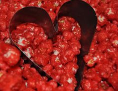 two heart shaped cookie cutters sitting on top of a pile of red candy