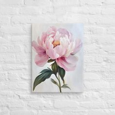 a large pink flower on a white brick wall with green leaves and buds in the center