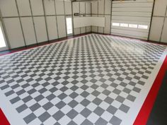 an empty garage with checkered floor and red trim