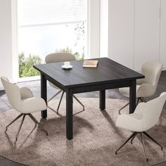 a dining table with four chairs around it and a book on the table next to it