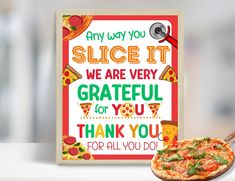 a pizza sitting on top of a table next to a sign that says, any way you slice it we are very grateful for you thank you for all you for all you