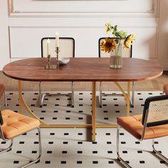 a dining room table with two chairs and a vase full of sunflowers on it