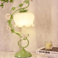 a green table lamp with white flowers on it