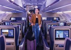 a woman standing on an airplane with her luggage