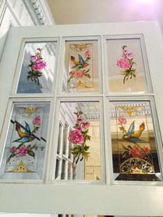 six stained glass windows with birds and flowers on them in a white frame hanging from the ceiling