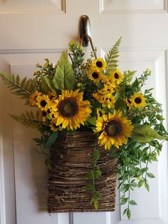 a basket filled with sunflowers hanging from a door