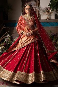 a woman in a red and gold bridal gown