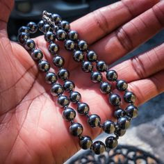 This simple 8mm hematite bead necklace is the perfect accessory to elevate your style to the next level. It pairs flawlessly with everyday wear as well as dressier outfits. The smooth round stones are highly reflective and can appear black, gray, or gunmetal blue. The stones in this gray-black stone necklace are approximately 8mm in diameter. Hematite stones are solid. The larger the stone, the more the necklace will weigh. The weight of this beaded necklace is a little over 2 ounces. In addition to being a gorgeous stone, Hematite is one of the materials given for anniversary gifts. Turquoise and steel are standard gifts for the 11th anniversary. Hematite jewelry is an alternative gift for the 11th anniversary. Because of its timeless appeal, Hematite jewelry will always be fashionable. A Gunmetal Blue, 11th Anniversary Gifts, Stone Bead Necklace, Hematite Jewelry, Alternative Gifts, Gray Necklace, 11th Anniversary, Hematite Necklace, Hematite Stone