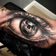 a man's arm with an eye tattoo on it