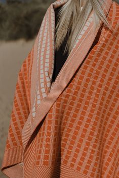 a woman wearing an orange and white striped jacket