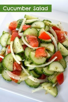 a white plate topped with cucumbers and tomatoes