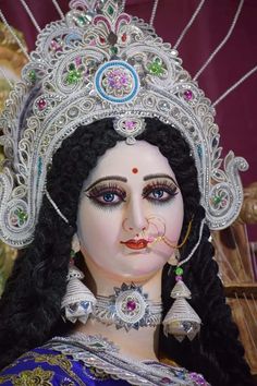 a close up of a statue of a woman wearing an elaborate headdress and jewelry