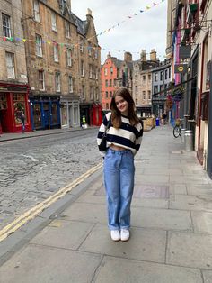 a woman standing in the middle of an empty street