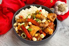 a bowl filled with rice and meat next to a red towel on top of a wooden table