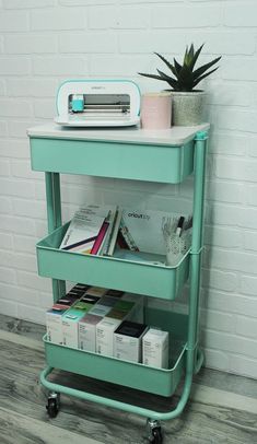 a green cart with magazines and a radio on it next to a white brick wall