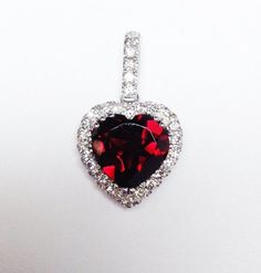 Up for sale is a Beautiful 14K White Gold Heart Shape Halo Garnet Gemstone Diamond Necklace Pendant.This classic Pendant features Genuine Garnet Gemstone. The stone is prong set in solid 14 Karat White Gold. An 18" inch 14K White Gold  1 gram chain is included.Specifications:-Model #: JK1065-Metal Type Available: White Gold, Rose Gold, Yellow Gold-Metal Purity: 14K-Halo Width: 12 MM x 12 MM-Stone Size: 8.5 MM x 8.5 MM  (Approximate weight 2.50 Carats)-Halo Height: 5 MM -Gold Weight: 2.5 Grams-To Hallmarked Wedding Pendant Gemstones, Luxury Wedding Pendant Gemstones, Diamond Heart Cut Gemstone Necklace, Heart Cut Diamond Gemstone Necklace, Heart Cut Cubic Zirconia Gemstone Necklace, Heart Cut Cubic Zirconia Gemstone Necklaces, Fine Jewelry Heart-shaped With Accent Stones, Heart Shaped Fine Jewelry With Accent Stones, Heart-shaped Fine Jewelry With Accent Stones