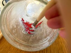 a person is stirring something in a glass bowl