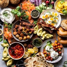 several different types of food are spread out on a table with plates and utensils