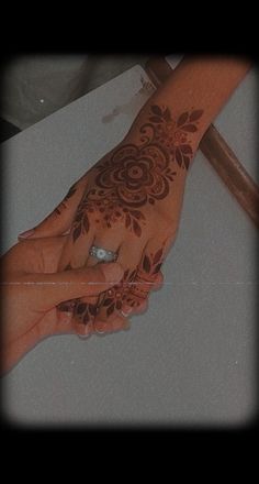 a woman's hand with henna on it and a diamond in the middle