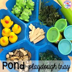 a blue tray filled with different types of toys and food on top of a wooden table