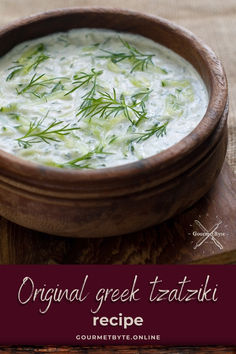 a wooden bowl filled with soup and garnished with green herbs on the side