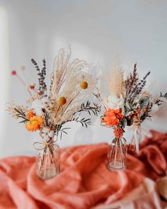 two vases filled with flowers on top of a bed