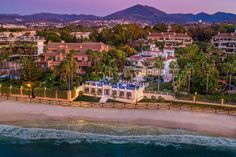 an aerial view of the beach and resort at sunset