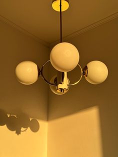 a chandelier hanging from the ceiling in a room with light shining on it