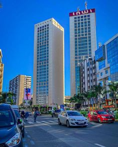 cars are parked on the street in front of tall buildings