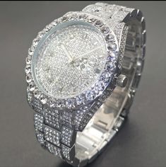 This Watch Is Completely Blinged Out And Heavy. Features: Silverplated Metal Stainless Steel Strap Metal Case Round Dial Shape Is Not Waterproof Quartz Movement Electronic Drive Mode Calendar Simulated Diamonds (Cz) Pointer Display Nice Quality Weight Men Jewelry Silver, Iced Out Round Jewelry For Anniversary, Metal Diamond Watch With Diamond Hour Markers, Stainless Steel Bling Watches As Gift, Iced Out White Gold Watch Gift, Silver Diamond Watch With Bling, Silver Diamond Analog Watch, Silver Diamond Watches With Bling, Classic Silver Iced Out Diamond Watch