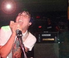 a young man singing into a microphone in front of an audience