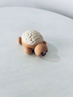 a small turtle toy sitting on top of a white table with no one around it