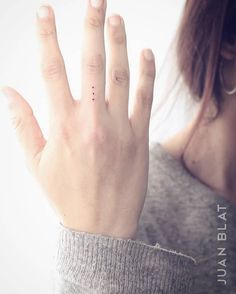 a close up of a person's hand holding something in the air with their fingers