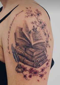 a woman's arm with an open book and flowers on it