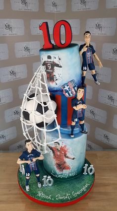 a soccer themed birthday cake with figurines on the top and bottom tiers