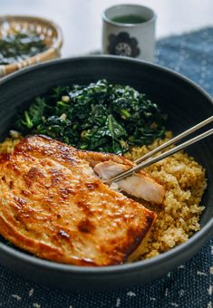 a bowl filled with rice, meat and greens