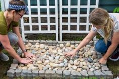 two women are placing rocks on the ground