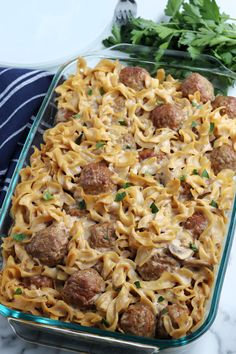 a casserole dish filled with meatballs and noodles