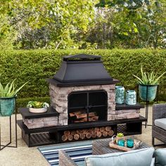 an outdoor fireplace surrounded by furniture and potted plants