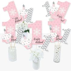 pink and gray baby shower decorations with snowflakes in vases on the table