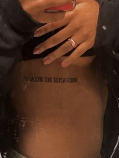 a woman's stomach with the words made in heaven tattooed on her belly and hand