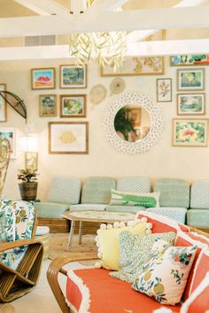 a living room filled with lots of furniture and pictures on the wall above it's couches