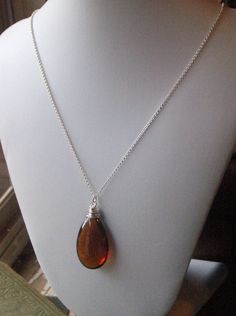 "on reserve for JA do not purchase unless you are she. I am absolutely, genuinely, unequivocally smitten over this dark amber crystal tear drop. I wrapped it in sterling silver wire to keep it pure and simple, for she is beautiful all on her own. She dances freely along 20\" of sterling silver rolo chain. Enjoy! p.s. Exciting news! This exact item went into a celebrity gift bag and was gifted to the beautiful & awesome (and my all-time favorite actress), Zooey Deschanel !! Be on the look out Everyday Brown Sterling Silver Jewelry, Sterling Silver Brown Wire Wrapped Jewelry, Brown Teardrop Jewelry For Gift, Brown Glass Necklace For Gift, Elegant Brown Jewelry Gift, Elegant Brown Jewelry For Gift, Elegant Amber Necklace Nickel-free, Elegant Amber Necklace Nickel Free, Brown Teardrop Necklace For Gift