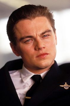 a close up of a person wearing a suit and tie with an eagle on his lapel