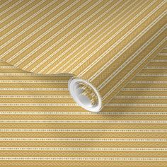 a yellow and white striped wallpaper with an intricate design on the bottom half of it