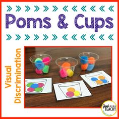 some sort of poms and cups on a table with different colored objects in them