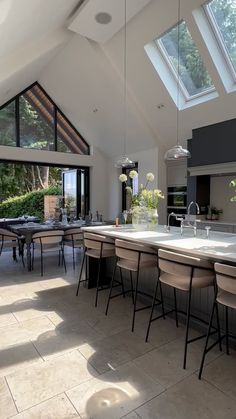 an open kitchen and dining room area with skylights above the countertop, along with large windows