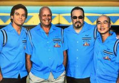 four men in blue shirts posing for a photo